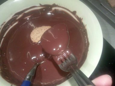 أثناء غمس قطع الحلوى في الشوكولاتة السوداء
