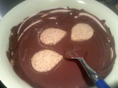 أثناء غمس قطع الحلوى في الشوكولاتة السوداء